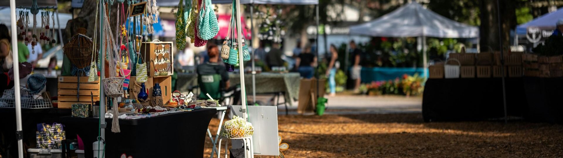A booth at an outdoor vendor market in a park