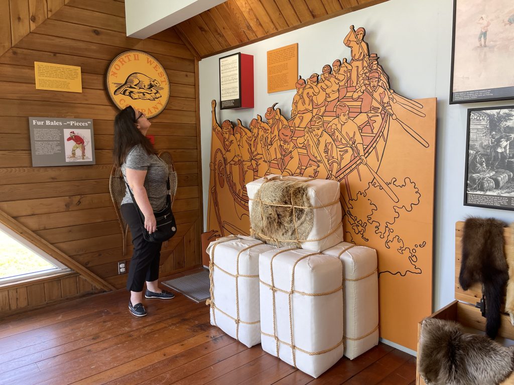 A guest reading about the fur trade inside the HMS Nancy museum